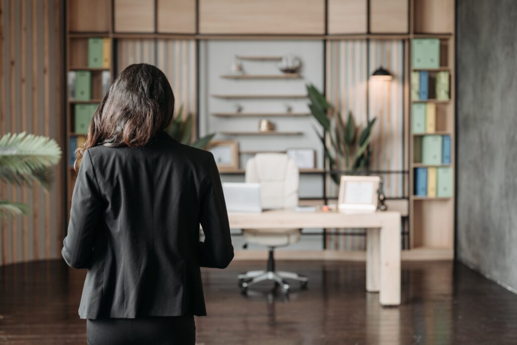 The back of a woman facing her desk